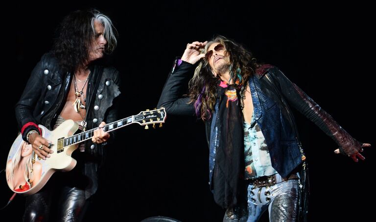 Вокалист группы Aerosmith Стивен Тайлер (справа) и гитарист Джо Перри выступают на концерте, посвященном Дню города на Лубянской площади в Москве