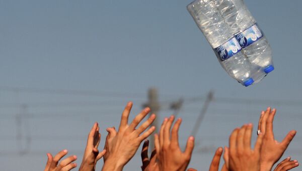 Мигранты ловят бутылки с водой на севере Греции недалеко от границы с Македонией