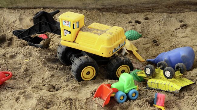 Игрушки в песочнице в детском саду