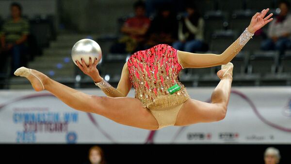 Маргарита Мамун выполняет упражнения с мячом на чемпионате мира по художественной гимнастике в немецком Штутгарте
