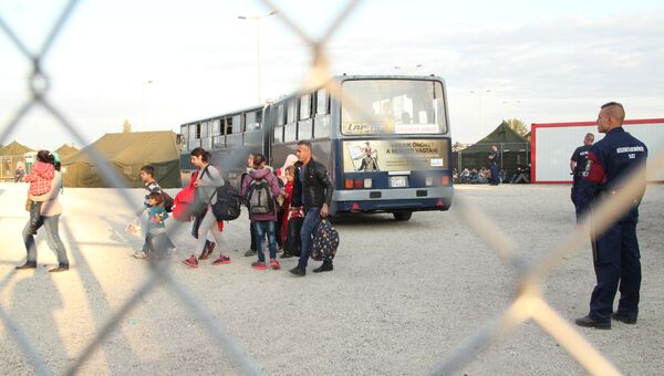 Беженцы заходят в миграционный пункт Реске