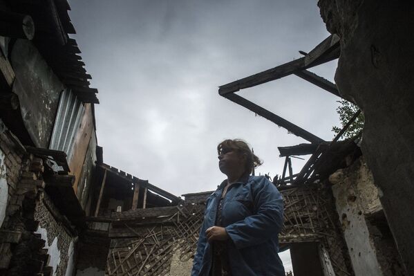 Ольга Бубнова во дворе своего дома, который был разрушен в результате попадания снаряда, в Донецке