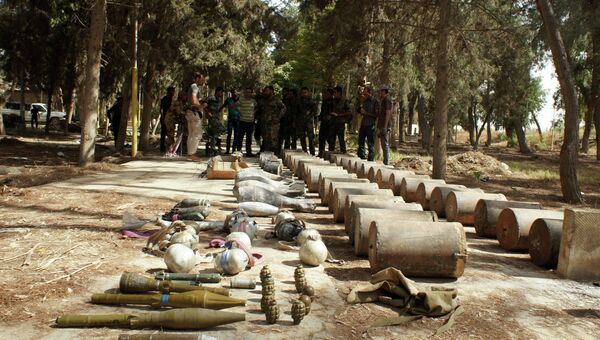 Сирийские военнослужащие досматривают трофеи, захваченные у боевиков ИГИЛ в Сирии