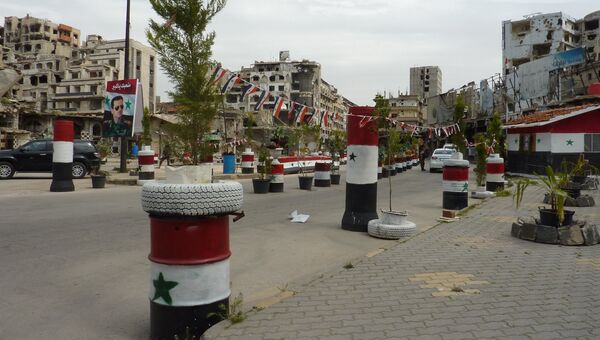 Улица с развешанными сирийскими флагами в городе Хомс, Сирия