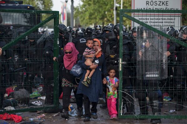 Венгерские полицейские отправляют мигрантов на территорию Сербии после столкновений на границе. 16 сентября 2015