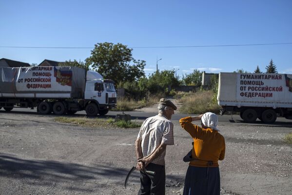 Местные жители наблюдают за проходом колонны машин 38-го гуманитарного конвоя в Донецкой области