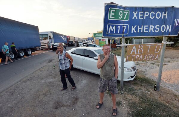 Водители наблюдают, как активисты заблокировали автодорогу на границе Украины и Крыма. 20 сентября 2015
