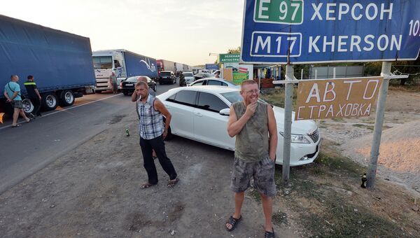 Водители наблюдают, как активисты заблокировали автодорогу на границе Украины и Крыма. 20 сентября 2015