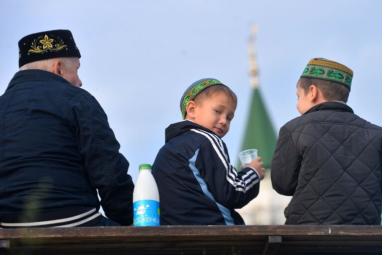 Мужчина с детьми после намаза на берегу озера Кабан у мечети Аль-Марджани в день празднования Курбан-Байрама в Казани