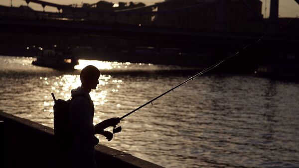 Молодой человек рыбачит в Москве. Архивное фото