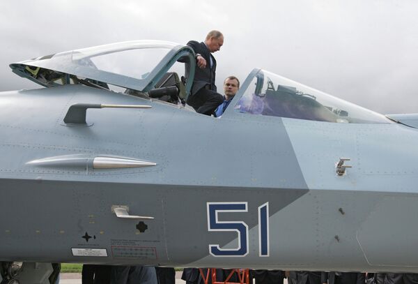 Председатель правительства России Владимир Путин с летчиком-испытателем (слева направо) у истребителя пятого поколения Т-50 разработки компании Сухой