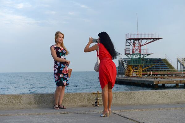 Женщины фотографируются на набережной города Керчь