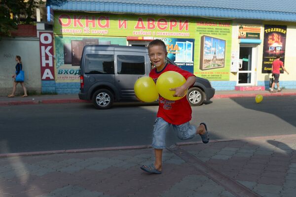 Мальчик с воздушными шарами бежит по одной из улиц Керчи