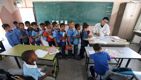 Учитель ставит оценки в классе английского языка начальной школы южной части сектора Газа