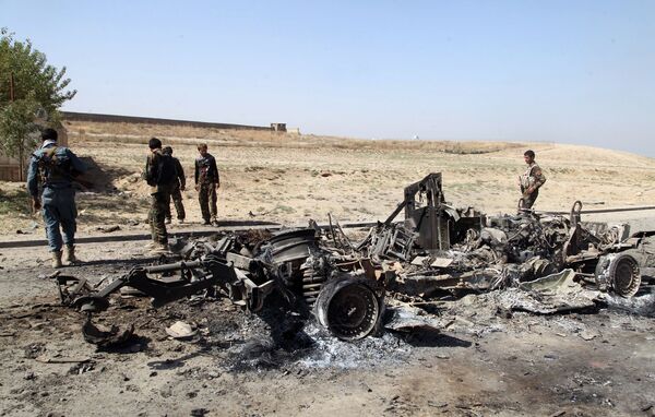 Афганские силы безопасности возле автомобиля, сгоревшего во время боя за Кундуз, Афганистан