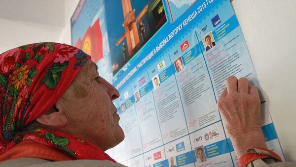 Женщина у списка кандидатов на избирательном участке в Киргизии