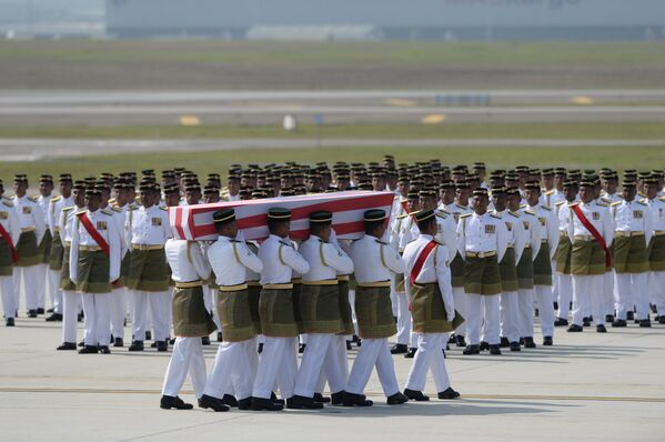 Военные несут гроб с останками жертвы крушения малайзийского самолета Boeing 777 в Донецкой области. Куала-Лумпур