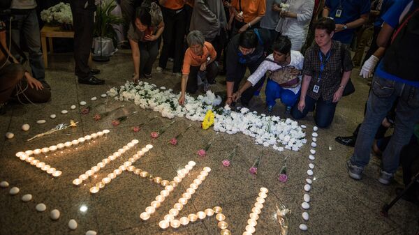 Люди возлагают цветы в память о погибших в авиакатастрофе малайзийского самолета Boeing 777 в районе города Шахтерск Донецкой области. Куала-Лумпур