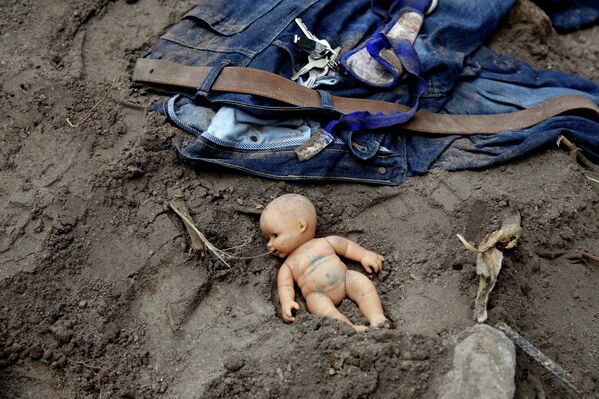 Кукла и личные вещи на месте оползня в районе поселка Санта-Катарина-Пинула, Гватемала