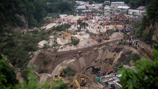 Спасатели на месте оползня в районе поселка Санта-Катарина-Пинула, Гватемала