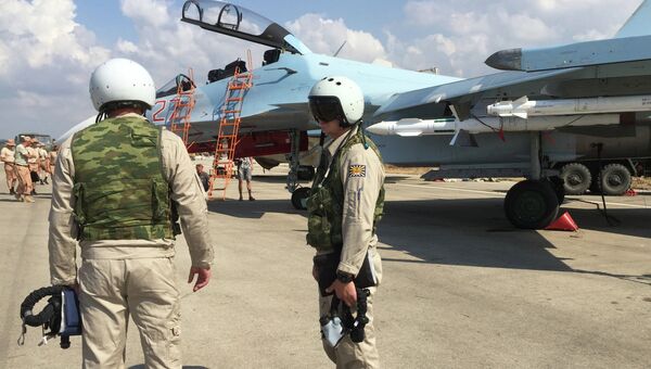 Российские летчики готовятся к посадке в истребитель Су-30 перед вылетом с аэродрома Хмеймим в Сирии