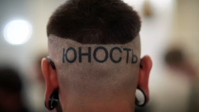 Татуировка в виде слова Юность на затылке молодого человека