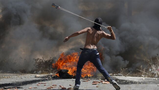 Демонстрант из Палестины бросает камни в сторону войск Израиля в ходе столкновений в Иерусалиме. Октябрь 2015 Демонстрант из Палестины бросает камни в сторону войск Израиля в ходе столкновений в Иерусалиме. Октябрь 2015