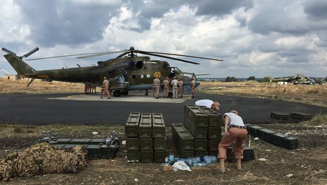 Технический персонал у российского ударного вертолета МИ-24 на аэродроме Хмеймим