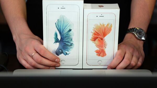 Продавец демонстрирует новые смартфоны Apple iPhone 6 и iPhone 6 plus
