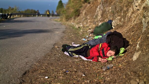 Сирийский мальчик с матерью спят на дороге после прибытия на остров Лесбос