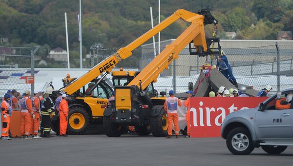Болид гонщика Торо Россо Карлоса Сайнса-младшего эвакуируют с трассы во время третьей сессии свободных заездов на российском этапе чемпионата мира по кольцевым автогонкам в классе Формула-1