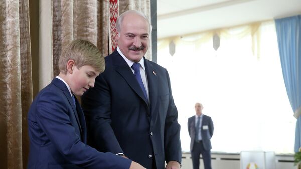 Президент Белоруссии Александр Лукашенко с сыном Николаем на избирательном участке №1 Центрального района Минска