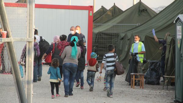 Беженцы заходят в миграционный пункт венгерской полиции. Архивное фото