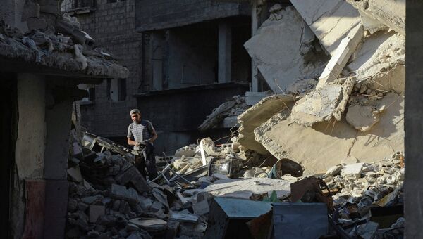 Местный житель на улице среди разрушенных зданий в районе Дахания в Дамаске. Архивное фото