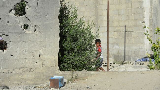 Местный житель на улице среди разрушенных зданий в районе Дахания в Дамаске