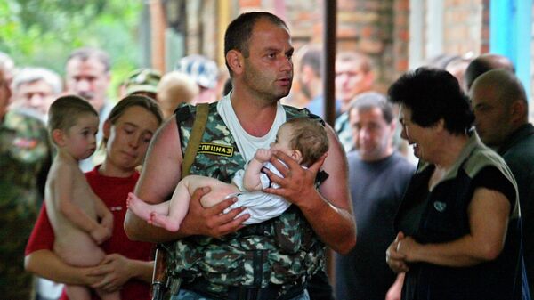 Боец спецназа несет спасенного ребенка во время штурма захваченной боевиками школы в Беслане. 2004 год