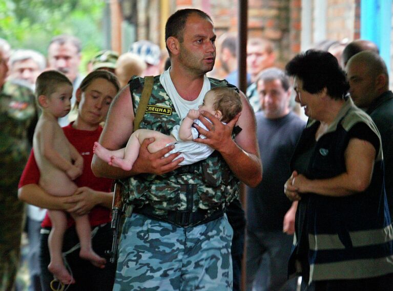 Боец спецназа несет спасенного ребенка во время штурма захваченной боевиками школы в Беслане. 2004 год