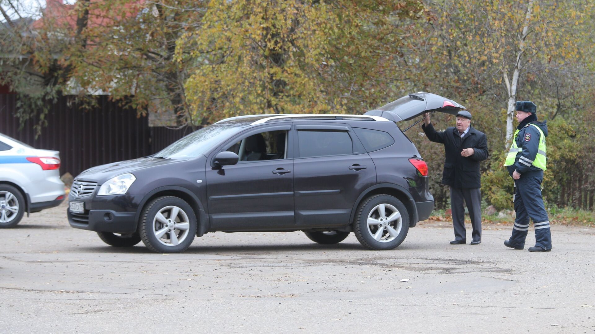 Сотрудник ДПС досматривает машину автовладельца на одной из улиц деревни Тимошкино - РИА Новости, 1920, 23.04.2021