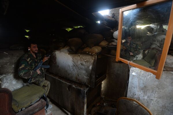 Боец 4-й дивизии Сирийской Арабской Армии на передовой позиции в пригороде Дамаска Дарайе