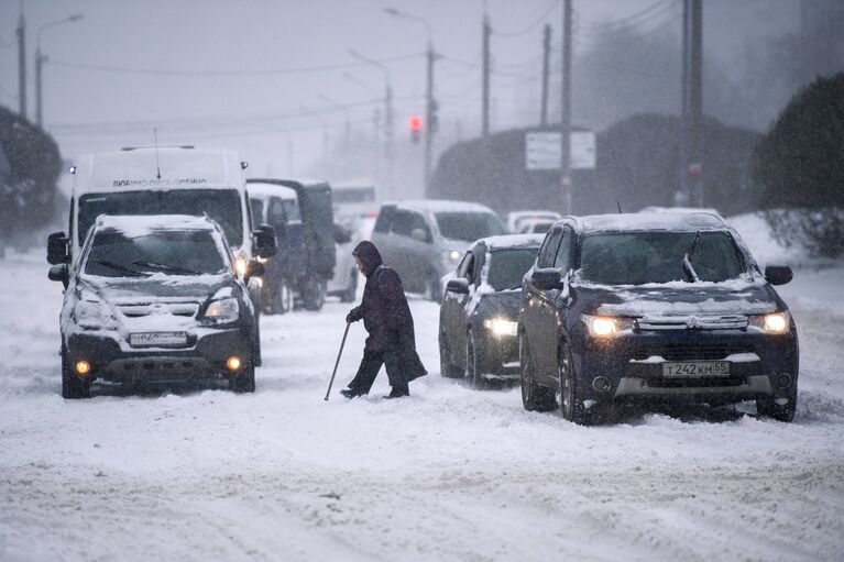 Местные жители на улице города Омска во время сильного снегопада