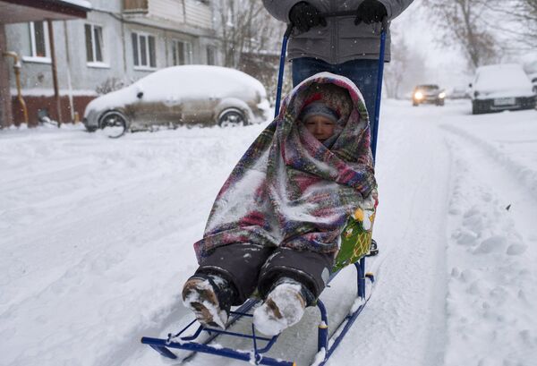Местные жители на улице города Омска во время сильного снегопада