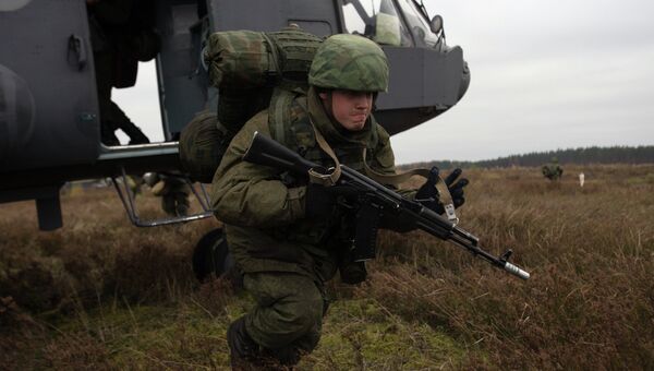Десантник ВДВ высаживается из вертолета Ми-8 на летно-тактических учениях армейской авиации Западного военного округа