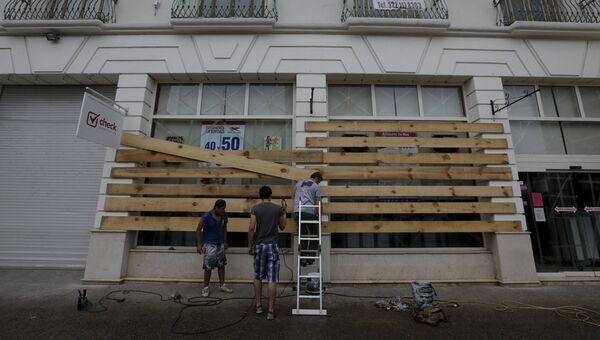 Рабочие в Мексике заколачивают окна перед ураганом Патрисия