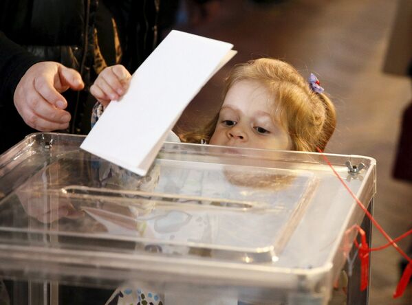 Девочка на избирательном участке в Киеве во время выборов в органы местного самоуправления