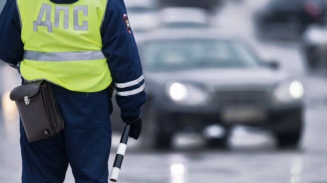 Сотрудник ГИБДД регулирует движение на Ленинградской площади в Омск