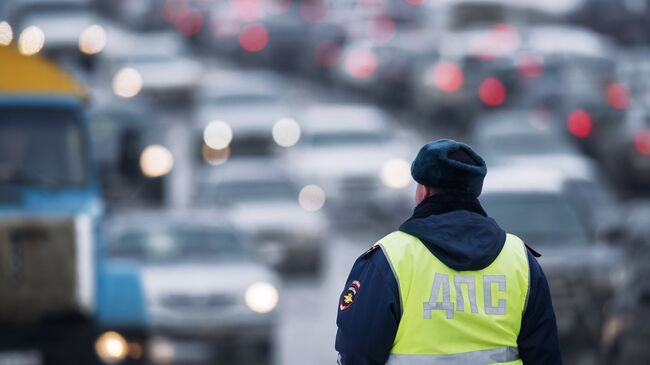 Сотрудник ГИБДД регулирует движение на Ленинградской площади в Омске