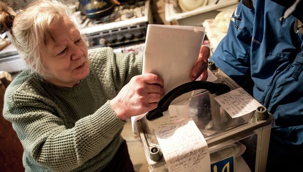 Пожилая женщина голосует на дому в Харькове во время выборов в органы местного самоуправления