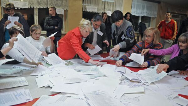 Сотрудники участковой избирательной комиссии на одном из избирательных участков Львова во время подсчета голосов на выборах в органы местного самоуправления