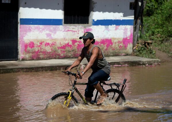 Местный житель на затопленной в результате прохождения урагана Патрисия улице в штате Халиско, Мексика