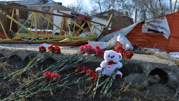 Цветы на месте падения башенного крана в Омске, в результате которого погибли четыре человека